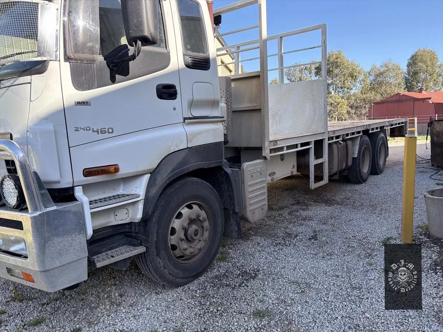 Isuzu flatbed truck before detailing, covered in road grime