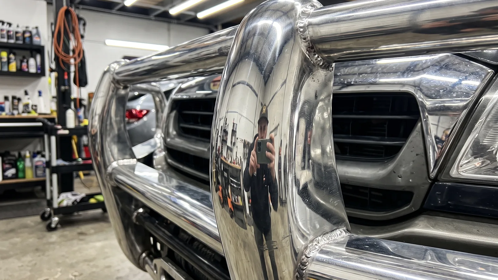 Close-up of a mirror-polished alloy bull bar tube and welds after aluminium polishing